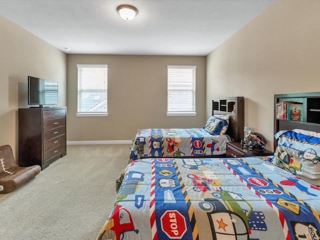 bedroom featuring light colored carpet and multiple windows