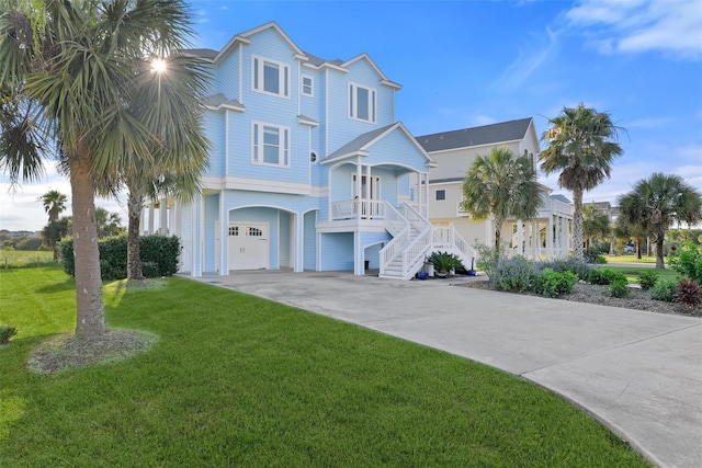 view of front of house with a front lawn, covered porch, and a garage