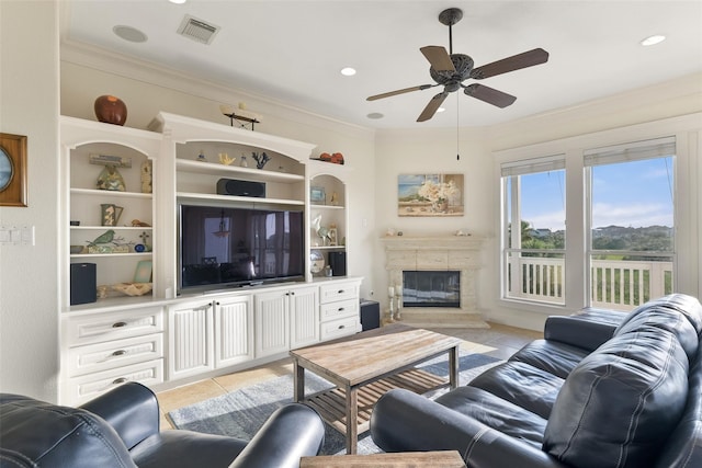 living room with ceiling fan, light tile patterned flooring, crown molding, and a fireplace