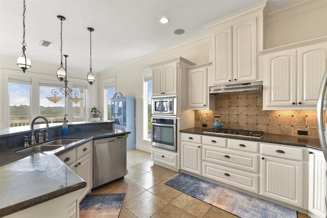 kitchen with pendant lighting, sink, stainless steel appliances, and ornamental molding