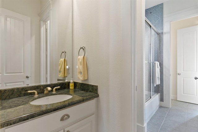 bathroom featuring tile patterned floors, vanity, and enclosed tub / shower combo