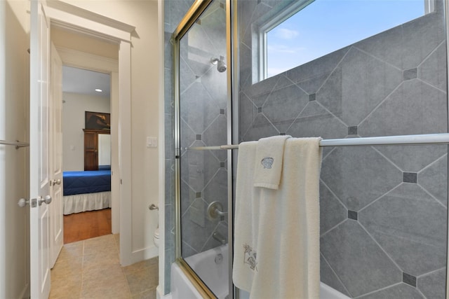 bathroom with shower / bath combination with glass door, tile patterned floors, and toilet