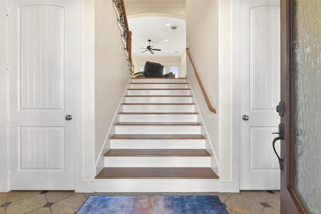 stairway with tile patterned floors and ceiling fan