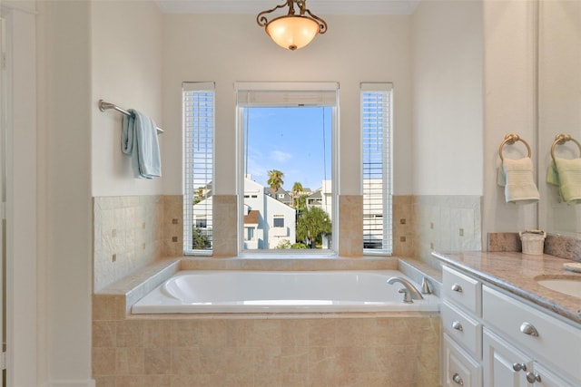 bathroom with vanity and tiled tub