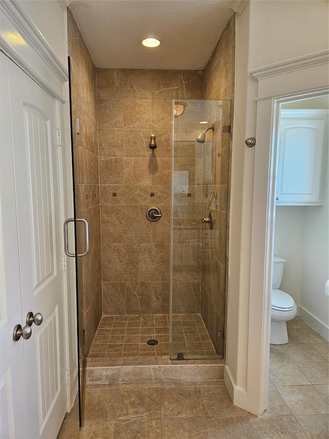 bathroom featuring walk in shower, tile patterned flooring, and toilet