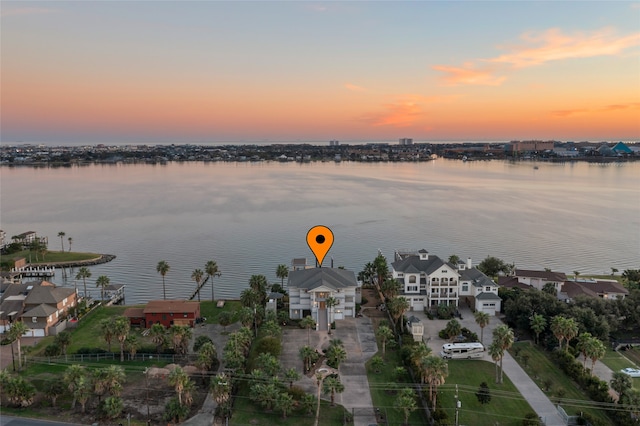 aerial view at dusk featuring a water view