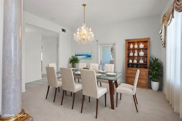 dining space with light carpet and an inviting chandelier