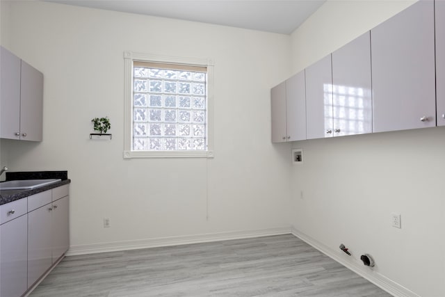 laundry area featuring sink, cabinets, washer hookup, hookup for a gas dryer, and light hardwood / wood-style flooring