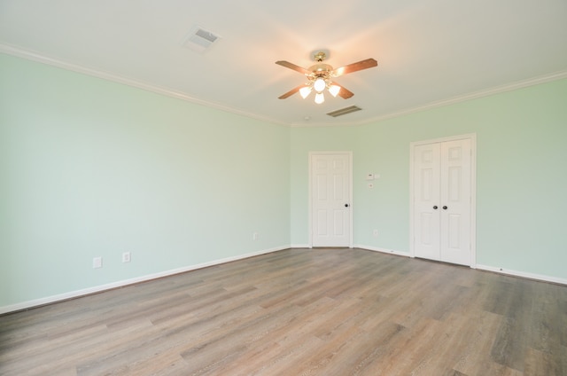 empty room with ceiling fan, light hardwood / wood-style floors, and ornamental molding