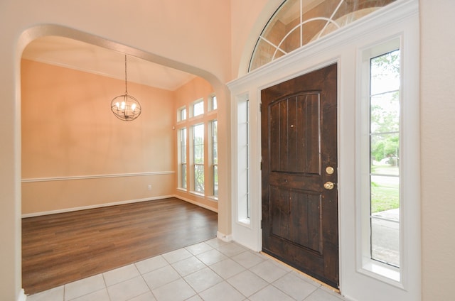 entrance foyer featuring a chandelier, crown molding, and light hardwood / wood-style flooring