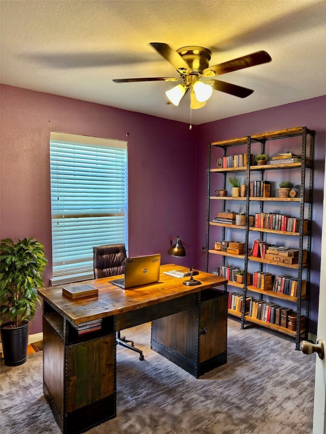 carpeted office featuring ceiling fan and a textured ceiling