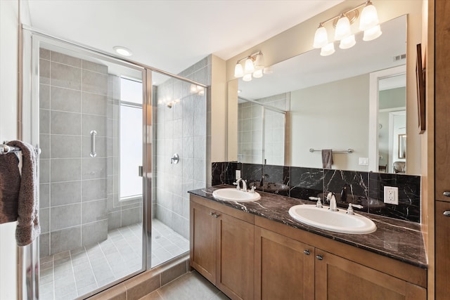 bathroom with tile patterned flooring, vanity, decorative backsplash, and walk in shower