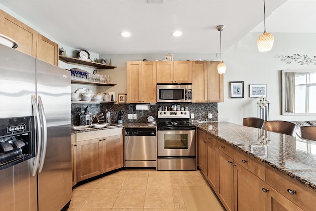 kitchen with dark stone counters, sink, decorative backsplash, appliances with stainless steel finishes, and decorative light fixtures