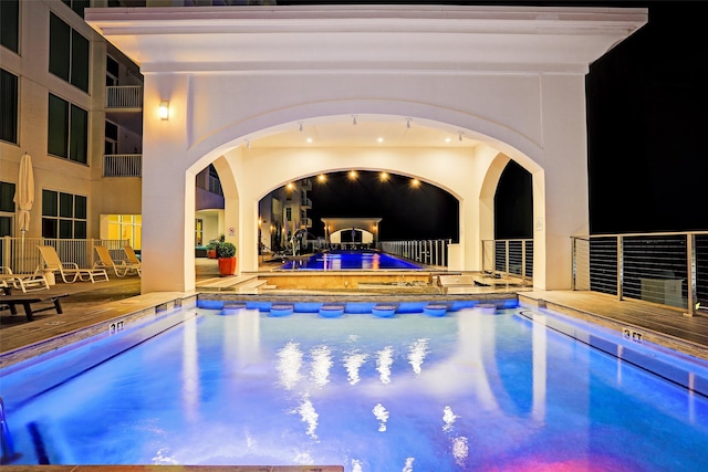 view of swimming pool featuring a jacuzzi and a patio