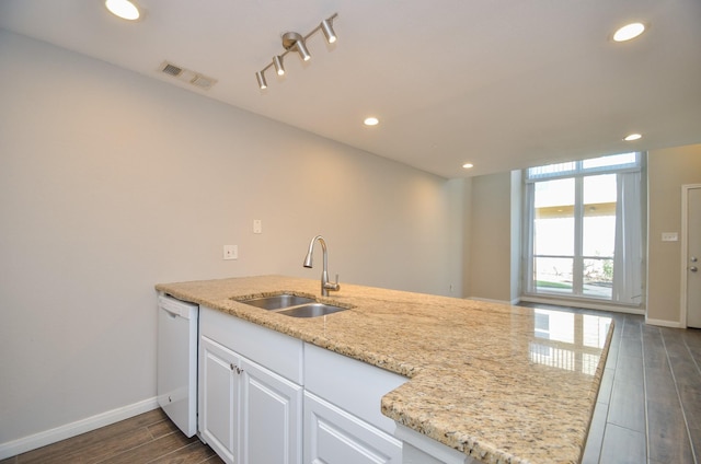 kitchen featuring light stone countertops, dishwasher, sink, dark hardwood / wood-style floors, and white cabinets