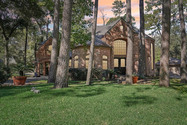 view of front facade with a yard and french doors