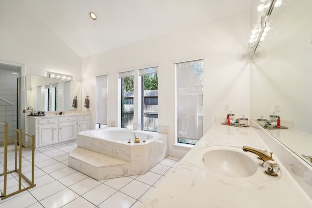 bathroom with tile patterned flooring, vanity, tiled bath, and high vaulted ceiling