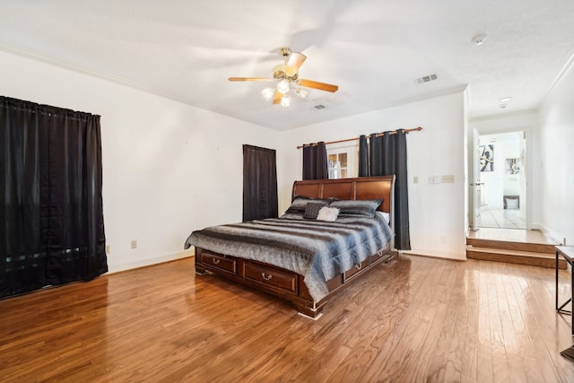 bedroom featuring light hardwood / wood-style flooring, ceiling fan, and ornamental molding