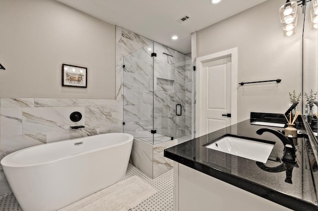 bathroom featuring tile patterned floors, vanity, separate shower and tub, and tile walls