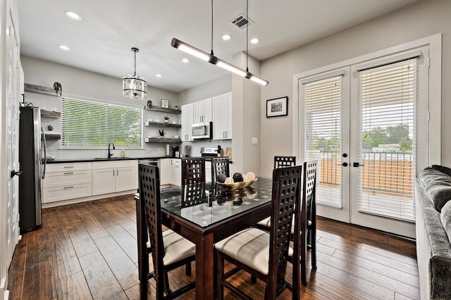 dining area with french doors, dark hardwood / wood-style flooring, a notable chandelier, and sink