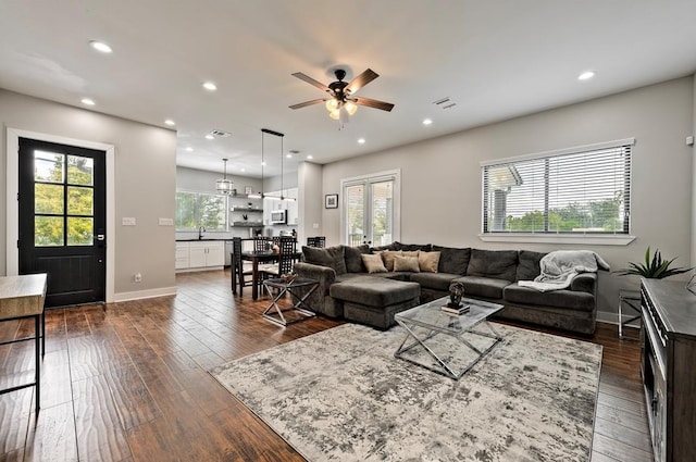 living room with ceiling fan, dark wood-type flooring, and a healthy amount of sunlight