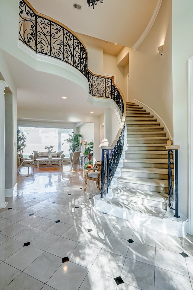 foyer with light tile patterned floors and a towering ceiling