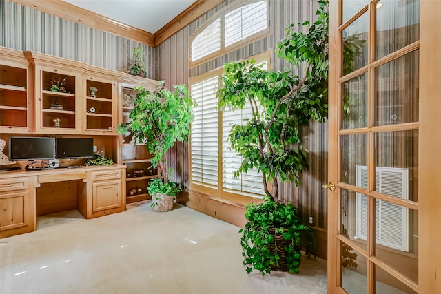 carpeted home office with built in desk and crown molding