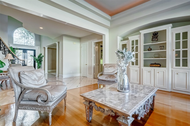 living area featuring light hardwood / wood-style flooring and ornate columns