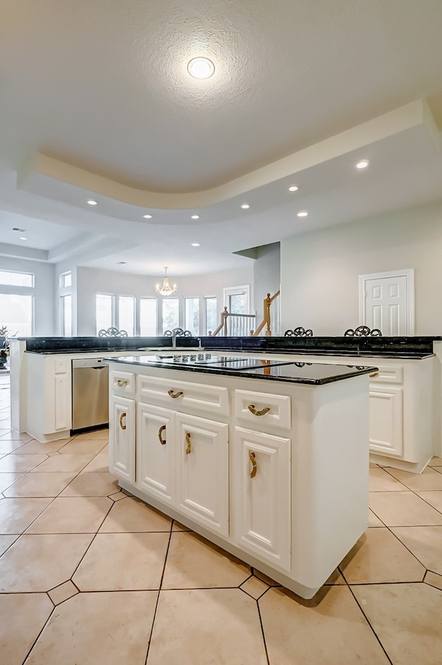 kitchen featuring dishwasher, light tile patterned flooring, white cabinets, a textured ceiling, and a kitchen island