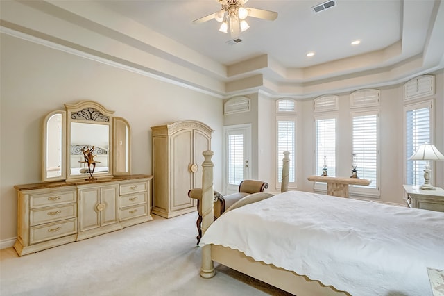 carpeted bedroom featuring a raised ceiling and ceiling fan