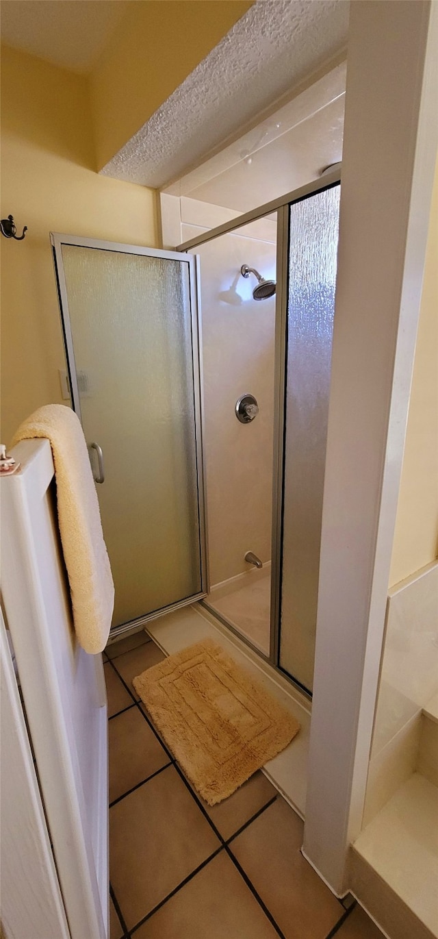 bathroom featuring tile patterned flooring and an enclosed shower