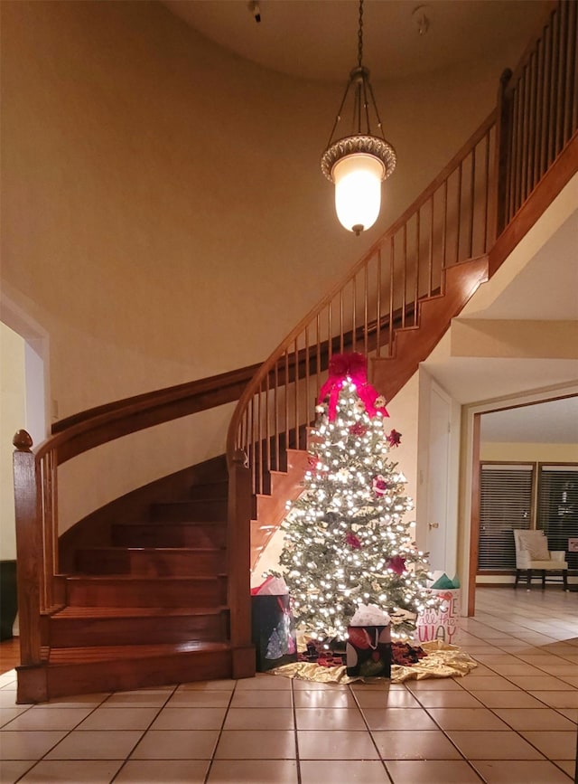 stairs with tile patterned flooring and a high ceiling