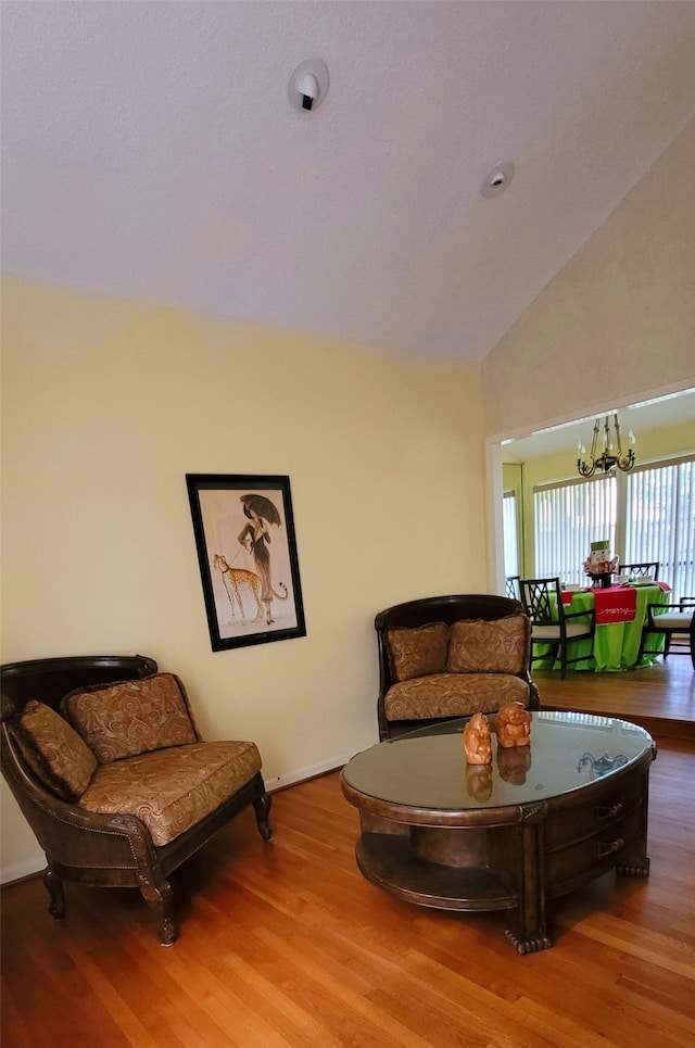 living room featuring a chandelier, hardwood / wood-style flooring, and high vaulted ceiling