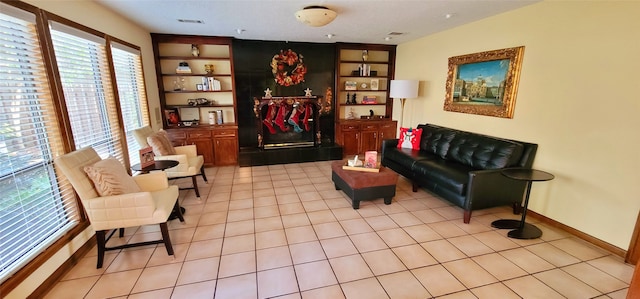 living area with built in shelves and light tile patterned floors