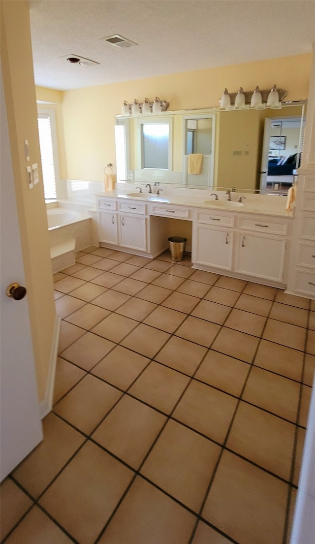 bathroom with a tub, tile patterned flooring, and vanity