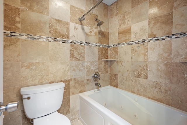 bathroom featuring tiled shower / bath, tile walls, and toilet