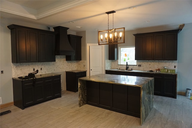 kitchen with hanging light fixtures, a kitchen island, light hardwood / wood-style floors, sink, and custom exhaust hood