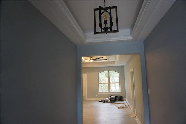 hall with crown molding and a raised ceiling