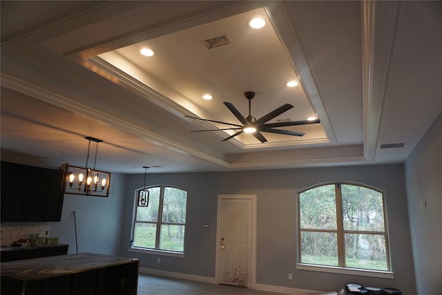 kitchen with a tray ceiling, crown molding, and ceiling fan