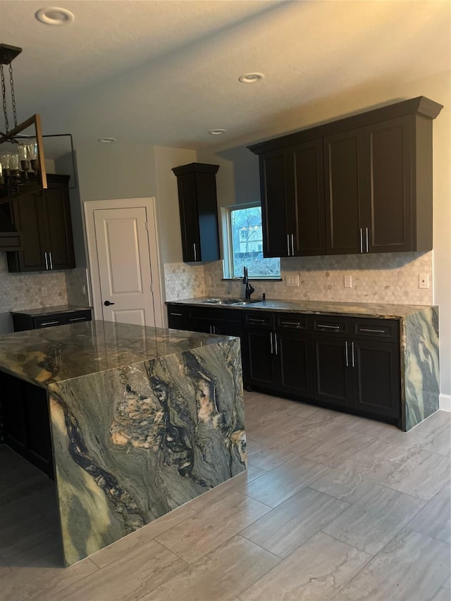 kitchen featuring sink, tasteful backsplash, and stone countertops