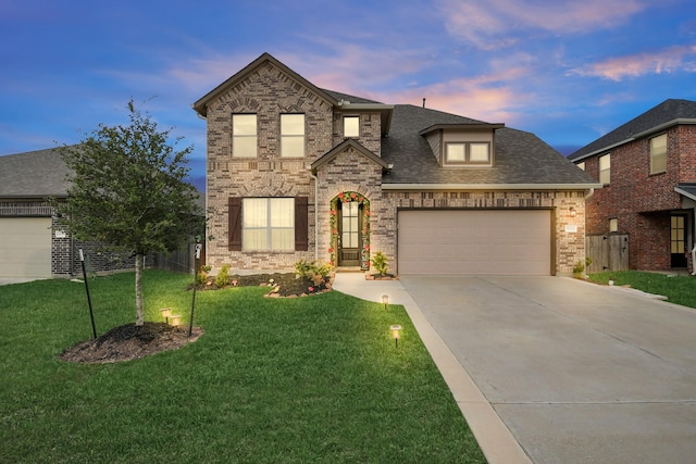 view of front of home with a yard and a garage