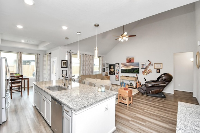 kitchen with a kitchen island with sink, sink, light hardwood / wood-style flooring, white cabinetry, and stainless steel appliances