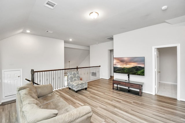 living room with vaulted ceiling and light wood-type flooring