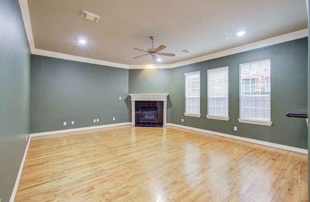 unfurnished living room featuring ceiling fan, light wood-type flooring, a fireplace, and ornamental molding