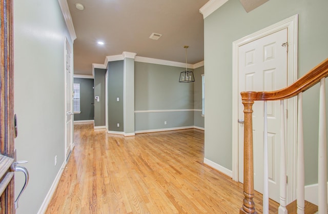 interior space featuring crown molding and light hardwood / wood-style floors