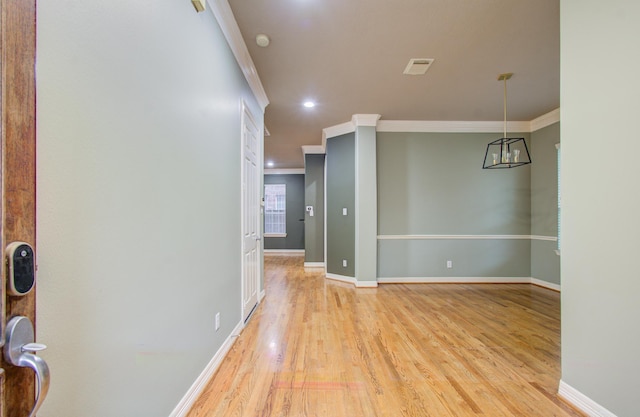 spare room featuring light wood-type flooring and crown molding