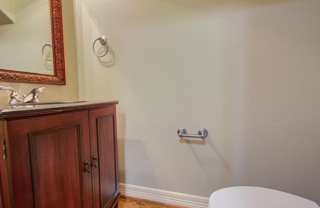 bathroom featuring vanity, wood-type flooring, and toilet