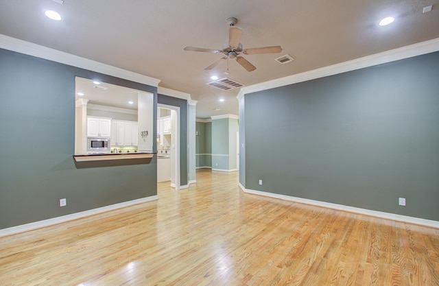 empty room featuring light hardwood / wood-style flooring, ceiling fan, and crown molding