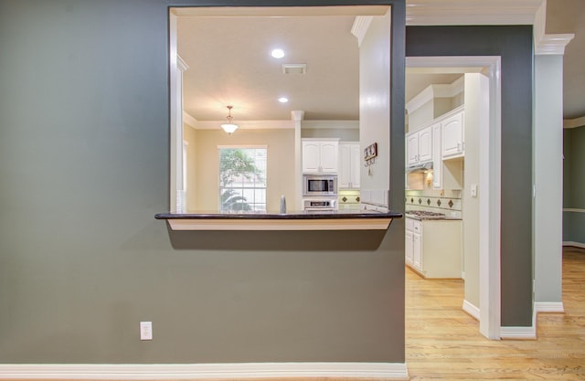 kitchen with kitchen peninsula, white cabinets, stainless steel appliances, and light wood-type flooring