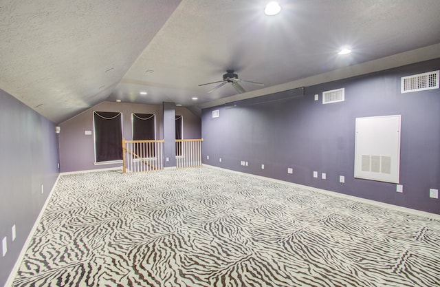 additional living space with a textured ceiling, ceiling fan, carpet, and lofted ceiling